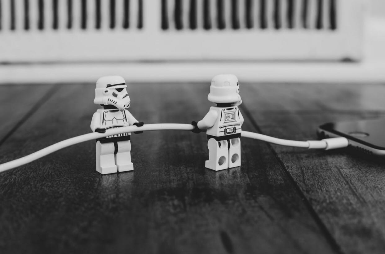 lego storm troopers pulling the charging cable out of an iphone... or maybe putting it in?